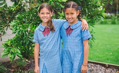 two Medowie primary school students in formal uniform with arms around each other smiling