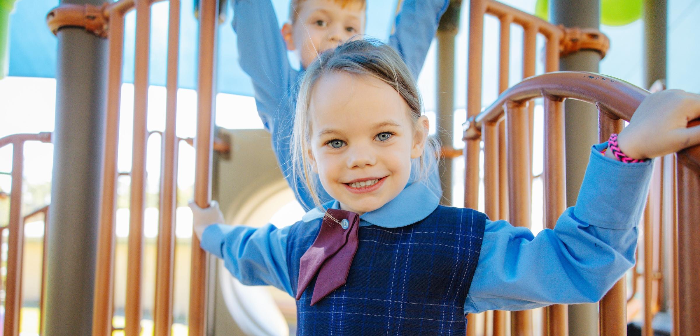 Close up of a smiling student on a playground, who is well known and nurtured by the community at Medowie Christian College.