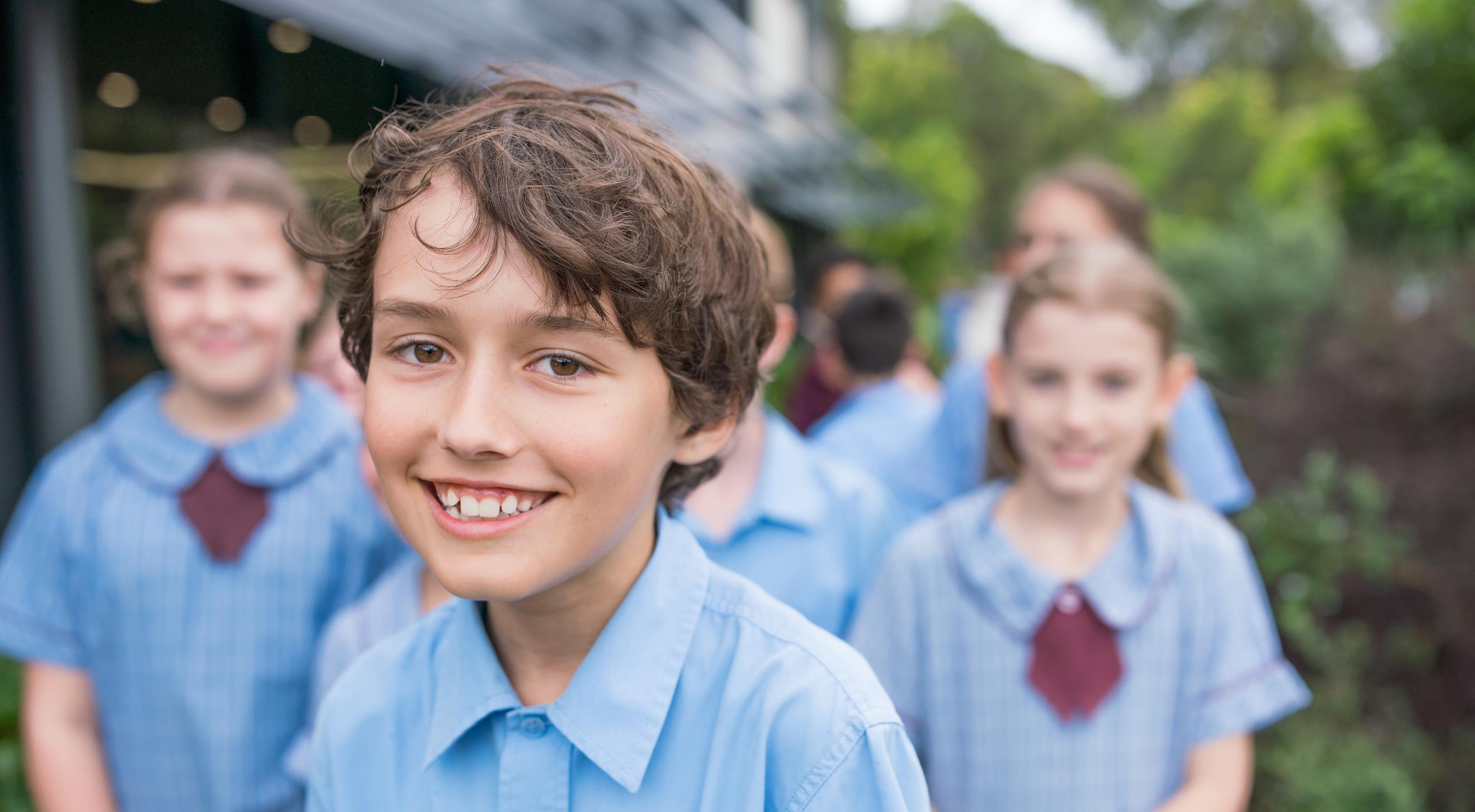 Close-up of a student smiling during a school tour, emphasizing the friendly atmosphere at the school.
