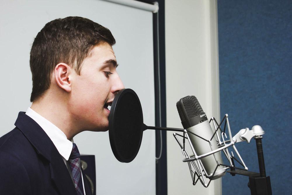 male student singing into microphone