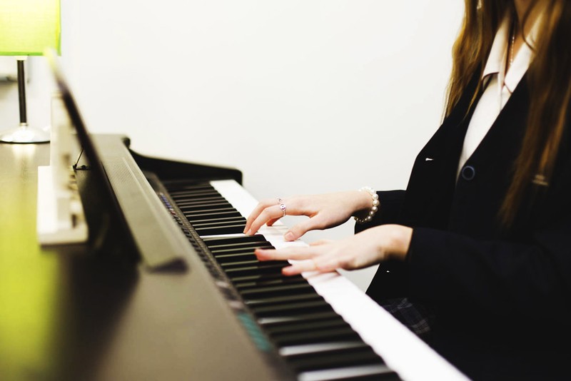 student practicing keyboard in music room